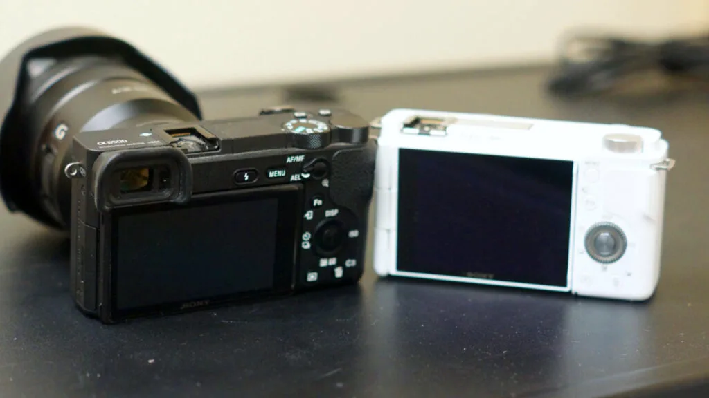 Rear comparison of Sony a6500 (with viewfinder) and ZV-E10 (no viewfinder) cameras.