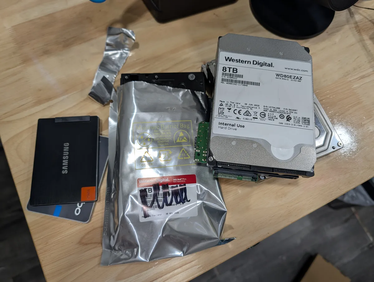 Western Digital Red Plus 8 TB (WD80EFAX/WD80EAZ) drive next to a Samsung SSD on a workbench.